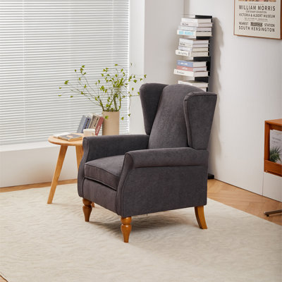 Une chaise de lecture confortable à haut dossier et une table basse en bois massif (couleur bois naturel)