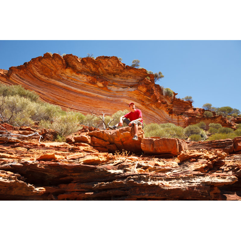 Man Sitting Bottom Of Colourful Layered Rock - Wrapped Canvas Print, 20cm H x 30cm W x 3.8cm D