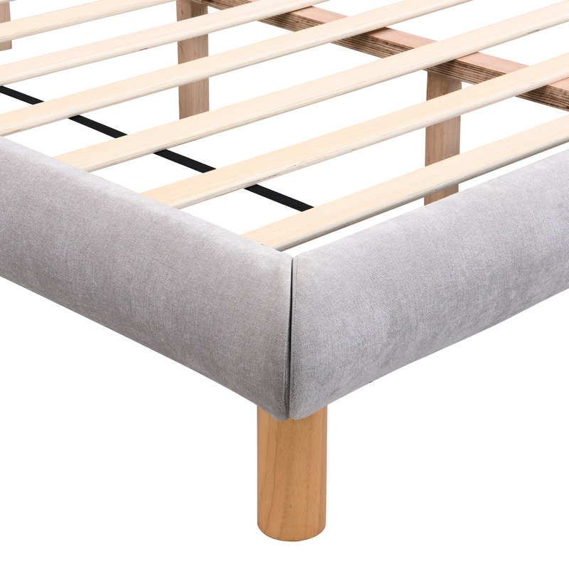 Confortable lit double gris avec tête de lit distinctive en forme de biscuit et structure stable en chenille