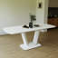 Table de salle à manger blanche extensible avec pieds robustes en forme de U pour une polyvalence élégante