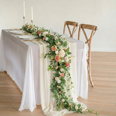 Guirlande de mariage avec guirlande florale avec chemin de table en chiffon, vigne de verdure et nappe diaphane