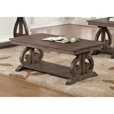 Table à finition chêne foncé avec base à volutes et rangement pratique