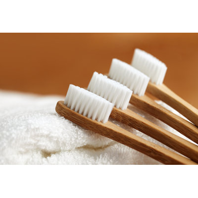 Four Bamboo Toothbrushes - Wrapped Canvas Print