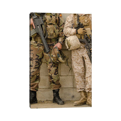 A Spanish Marine And A US Marine Relax Against A Wall by Stocktrek Images - Wrapped Canvas Print