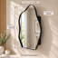 Armoire à miroir murale en forme de nuage irrégulier, avec cadre en métal et étagères en verre ajustables, noir mat