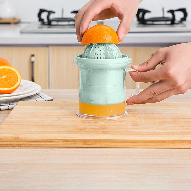 Presse-agrumes manuel pressant la tasse à citron avec balance tenant la main et pressant le jus, Green