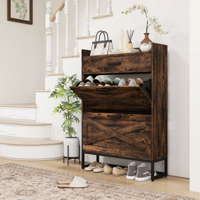 Armoire à chaussures rustique brun. 2 portes rabattables et un tiroir supérieur. Peut contenir jusqu'à 12 paires. Convient aux couloirs. Structure en panneau de particules et base en acier. Style industriel. Assemblage requis