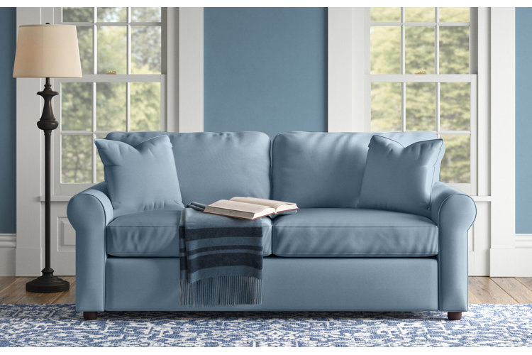 living room with soft blue sofa, rug, and walls
