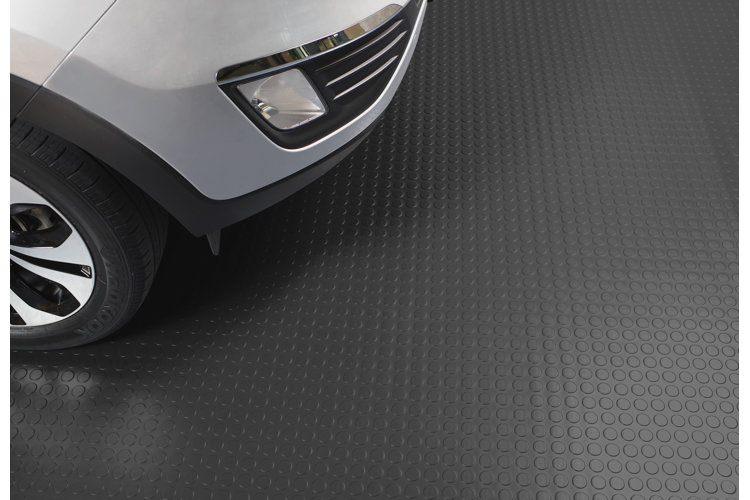 black interlocking tile garage flooring with a car parked on top of it
