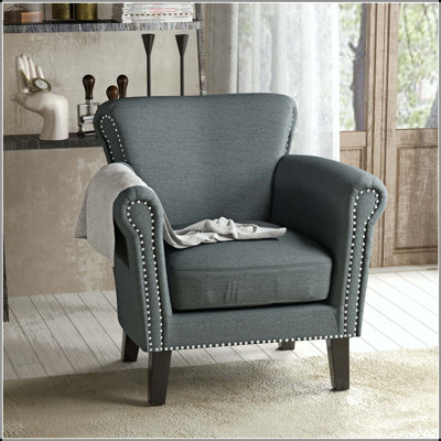 Fauteuil club avec garniture cloutée, accoudoirs roulés et pieds en bouleau