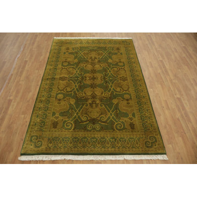 Tapis artisanal complexe dans des teintes dorées et vertes pour votre salon