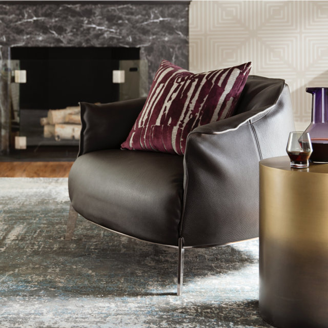 Leather chair with decorative pillow next to side table.