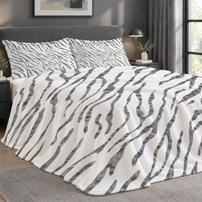 Ensemble de 3 pièces comprenant une couverture légère en flanelle de qualité supérieure et 2 taies d'oreiller à rayures zébrées abstraites noires et blanches ondulées, ultra-douce et chaude, idéale en toute saison. Couverture 152 x 203 cm + 2 taies d'oreiller anti-boulochage et lavables à la machine.