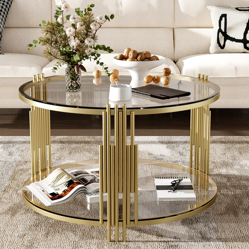 Table basse moderne en verre avec base asymétrique en métal, conception de tambour circulaire, finition dorée et tablette inférieure pour un rangement supplémentaire