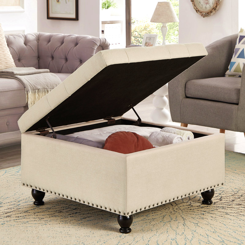 Grand repose-pieds carré avec rangement et pieds en bois, table basse capitonnée avec garniture cloutée pour espace de vie, beige