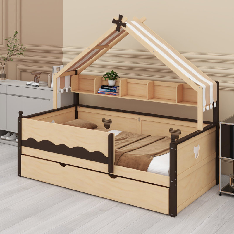 Le lit de jour avec lit gigogne et tablette est doté d'une structure à baldaquin en forme de maison pour les chambres d'enfants.
