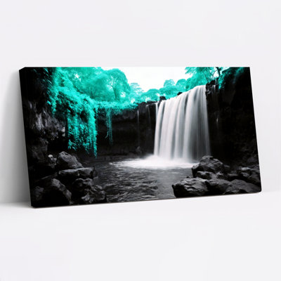 Tableau sur toile représentant un paysage de cascade, dans les tons turquoise et noir, idéal pour décorer un salon ou une chambre.