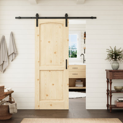 Porte intérieure en pin massif à deux panneaux cintrée de 30 po x 80 po avec quincaillerie noire de style grange, idéale pour le salon ou le garde-manger.