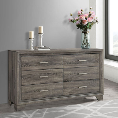La commode et la commode avec une finition en bois rustique et des poignées subtiles combinent charme rétro et rangement spacieux pour la chambre à coucher