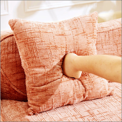 Canapé compressible rose à deux places avec accoudoirs et coussins, parfait pour les petits appartements et les espaces de vie confortables.