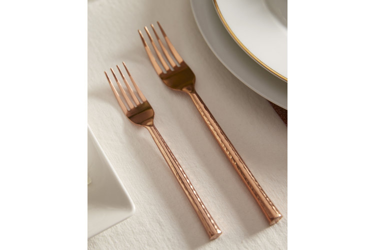 Copper forks on a white napkin.