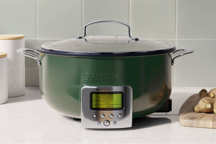 green metal slow cooker on a marble countertop