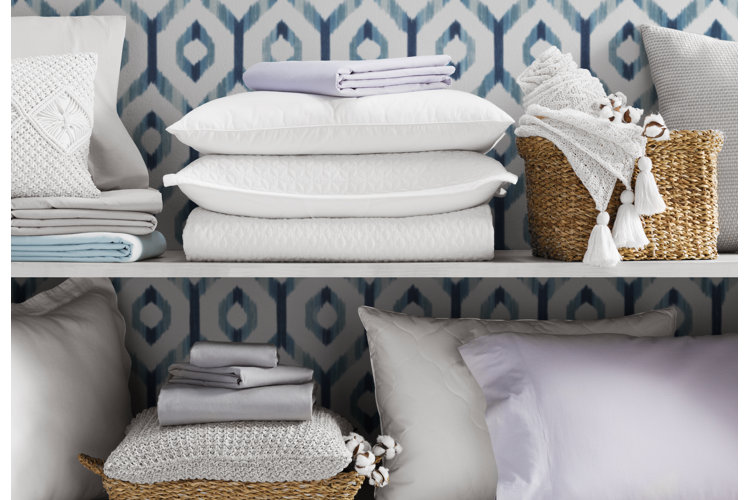 shelves filled with an array of bedding ranging through blankets and pillows, some of which are stored in baskets