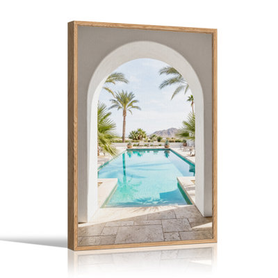 Tableau sur toile représentant une piscine turquoise et des montagnes à travers une arche blanche