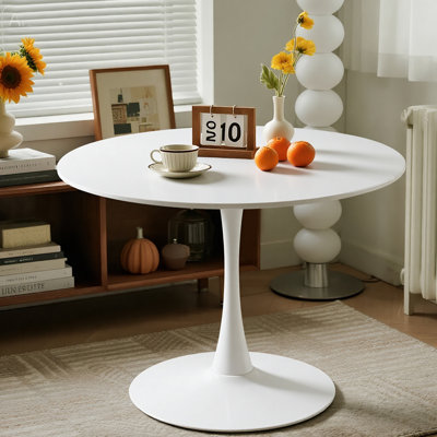 Une table de salle à manger ronde blanche de style luxueux, dotée d'une élégante base en métal en forme de tulipe et d'un plateau en panneau de fibres à densité moyenne de 31,5 pouces, présente un style médiéval moderne dans son ensemble. It