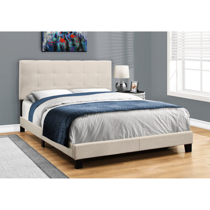 Lit tapissier beige en lin avec pieds noirs stables et tête de lit plateforme