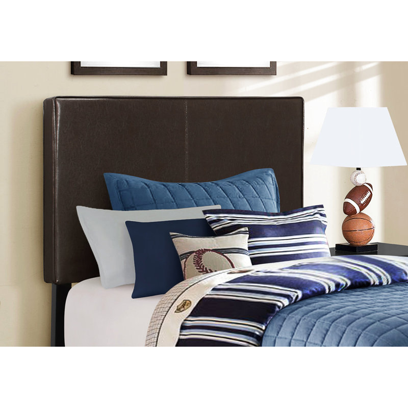 Lit simple à profil bas avec revêtement brun pour le décor de la chambre tapissée dans un environnement sombre et tranquille