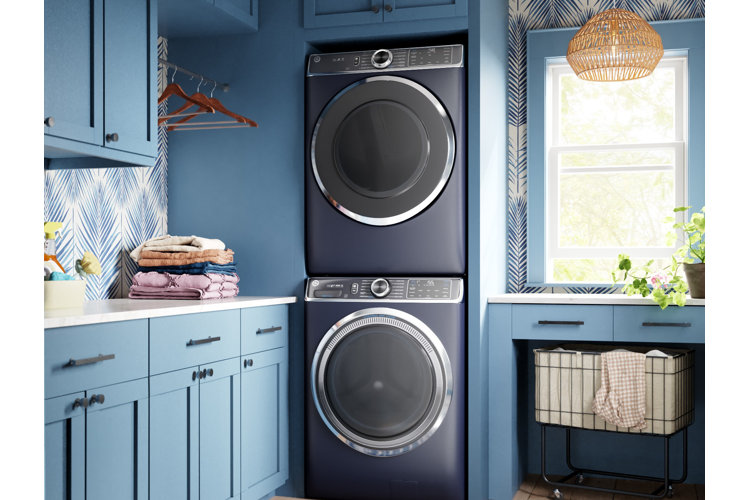 Laundry room lighting ideas with A Blue laundry room with blue walls and cabinets a navy blue washer and dryer set and a rattan pendant light fixture on the ceiling