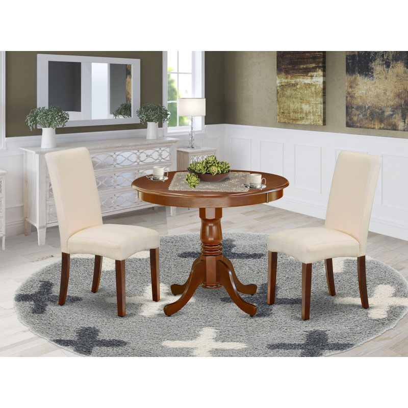 L'ensemble 3 pièces de table et chaises de cuisine comprend une table de salle à manger ronde avec piédestal et 2 chaises de salle à manger Parson en tissu crème, acajou