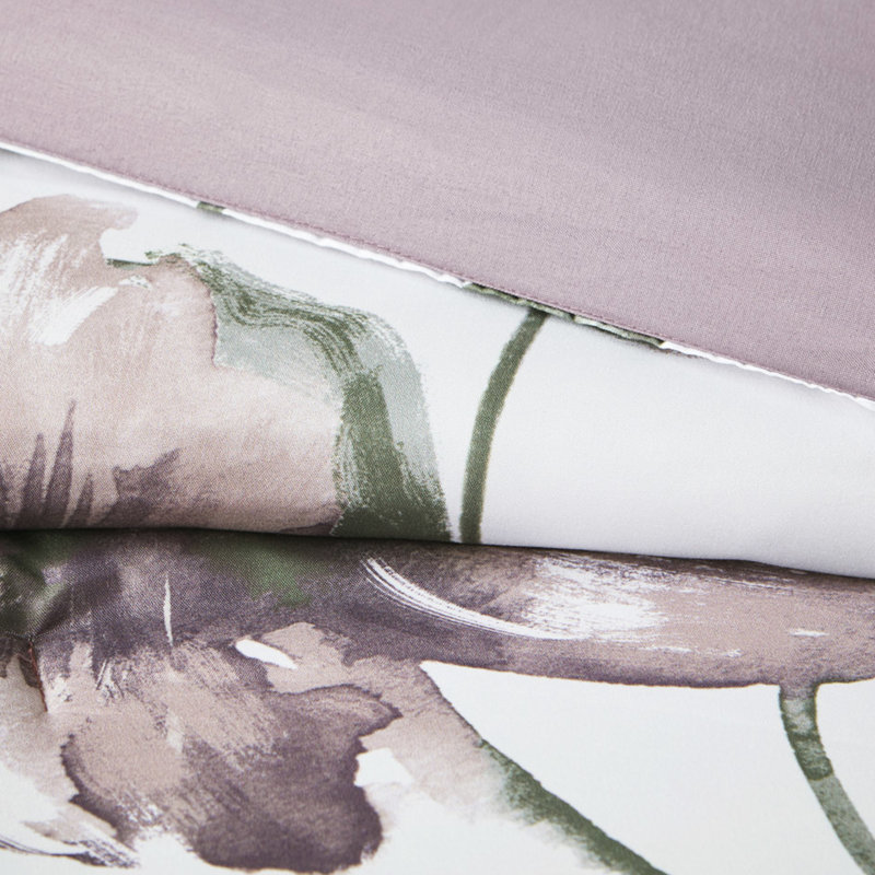 Édredon et drap mauve à motif floral pour une chambre douillette avec taupe