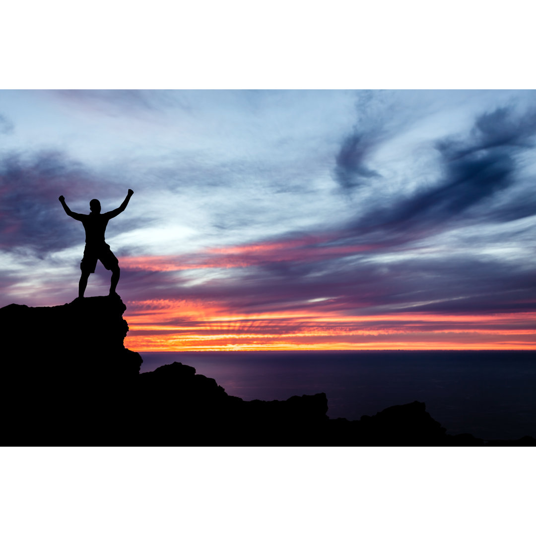 Leinwandbild Mann Wandern Silhouette in Berge Meer und Sonnenuntergang