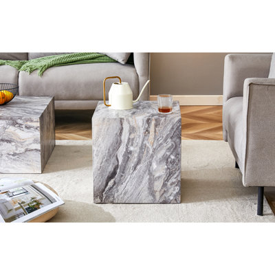 Rehaussez votre espace de vie avec cette table basse moderne en bois aggloméré, qui met en valeur des motifs texturés. Il est caractérisé par un design élégant.