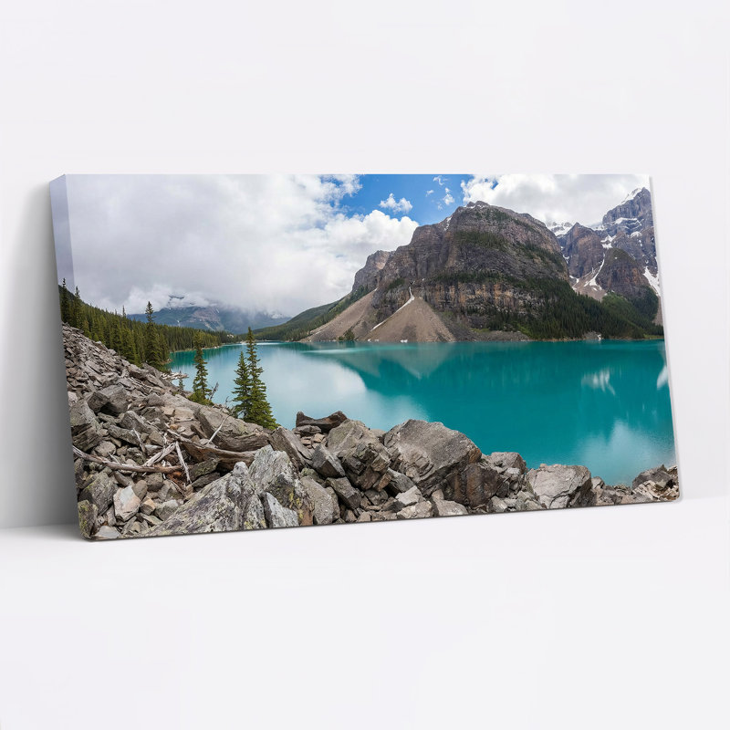 Tableau sur toile représentant un lac de montagne turquoise avec rivage rocheux et pins, 46“W x 24”H