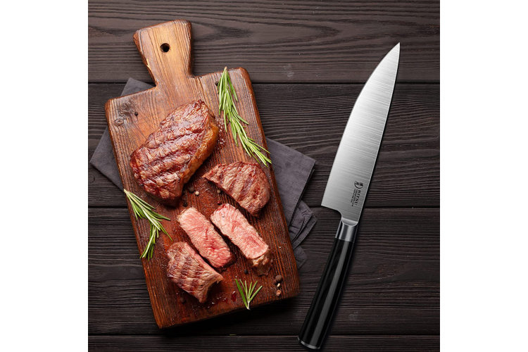 Chef's knife beside sliced meat.
