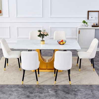 Ensemble de table et de chaises. Table de salle à manger en verre à motif de neige blanche de style montagne de luxe moderne - 71 po x 35,4 po avec pieds dorés en forme de U. Assortie de 6 chaises en polyuréthane blanc avec pieds en métal noir.
