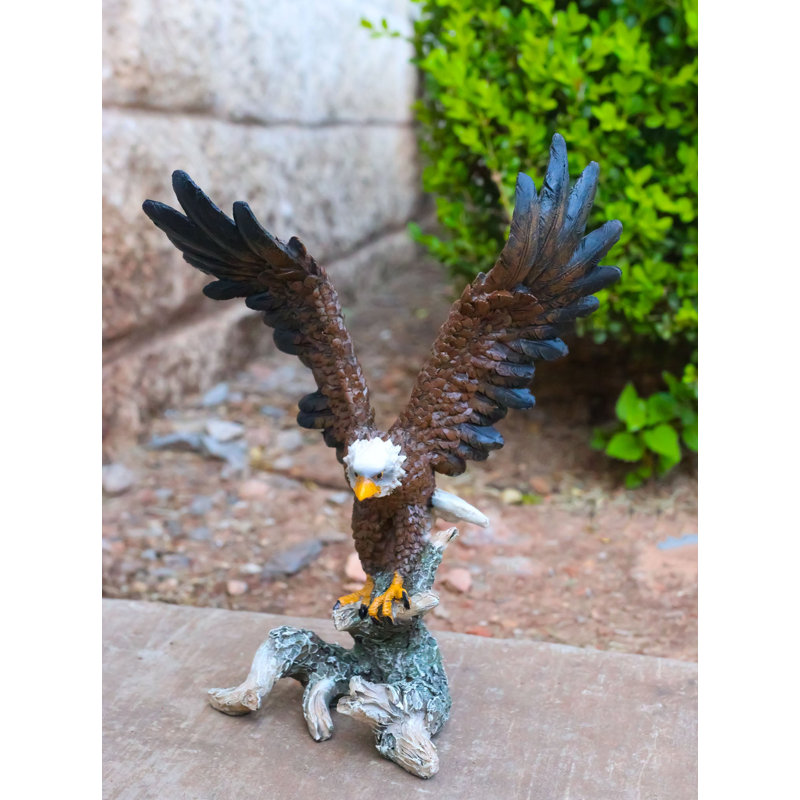 Grande figurine d'aigle à tête blanche avec des ailes déployées prenant son envol d'une branche d'arbre