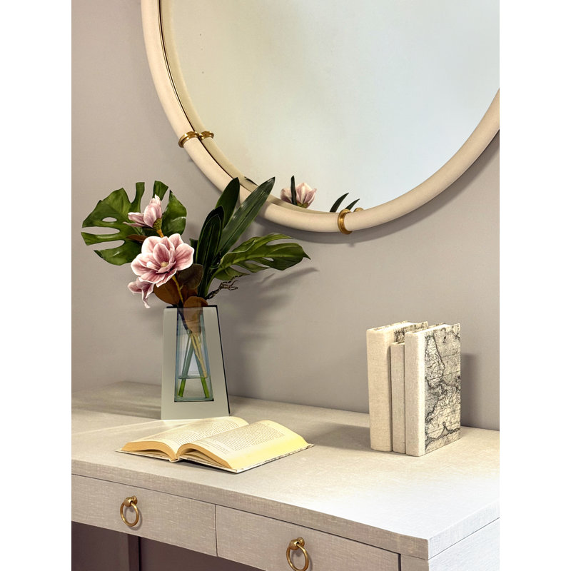 Magnolia, Philo et feuille d'orchidée disposés dans un vase miroir en verre