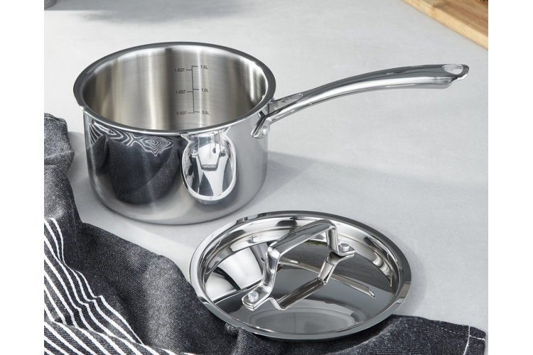 Stainless steel saucepan and lid next to a gray and white kitchen towel