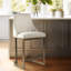 Tabouret de hauteur de comptoir moderne H 26 po - rembourré avec une base en métal, des accoudoirs incurvés et un dossier arrondi pour une structure sophistiquée. Revêtement en mousse à haute densité.