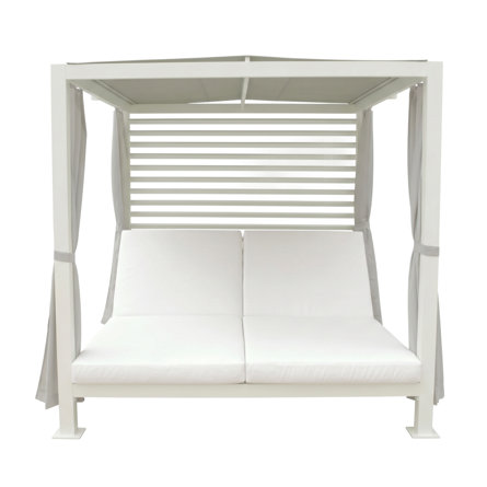 White outdoor daybed with canopy and curtains.