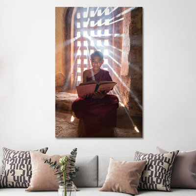 Burmese Novice Monk Reading A Book In A Temple, Bagan, Myanmar by Jan Becke - Wrapped Canvas Print