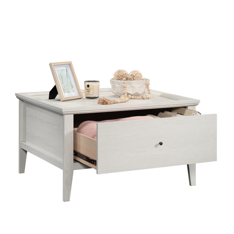 Table basse grise avec tiroir coulissant, design élégant et placement flexible – idéale pour exposer des objets.
