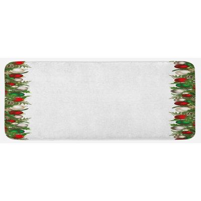 Ornements xmas avec des piquets de pin les baies rouges sont un tapis de cuisine vert foncé et rouge foncé