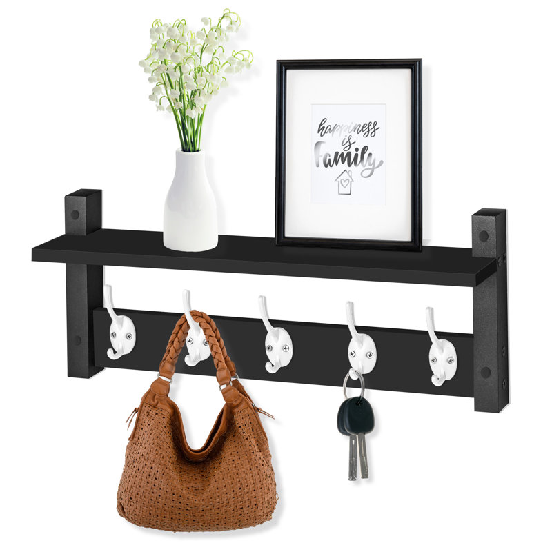 Black wall-mounted floating shelf with five white hooks, styled with a vase, picture frame, handbag, and keys.