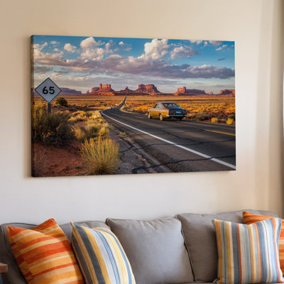 Toile, "Winding Desert Road Stretches In The Distance Borded By", art mural, "Red Rock Formations Under A Vibrant Sunset Sky", art mural