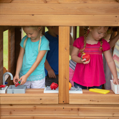 Backyard Discovery Aspen Cedar Wooden Kids Playhouse with Play Kitchen, Snack Bar Window, and Picnic Bench